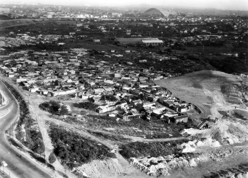 Nanterre : bidonville de la rue de la Garenne, La Défense et Paris en arrière plan. Vers 1960 - 20Fi1/NAN_34